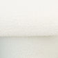 Close-up of textured white boucle upholstery on modern furniture from FredCo International