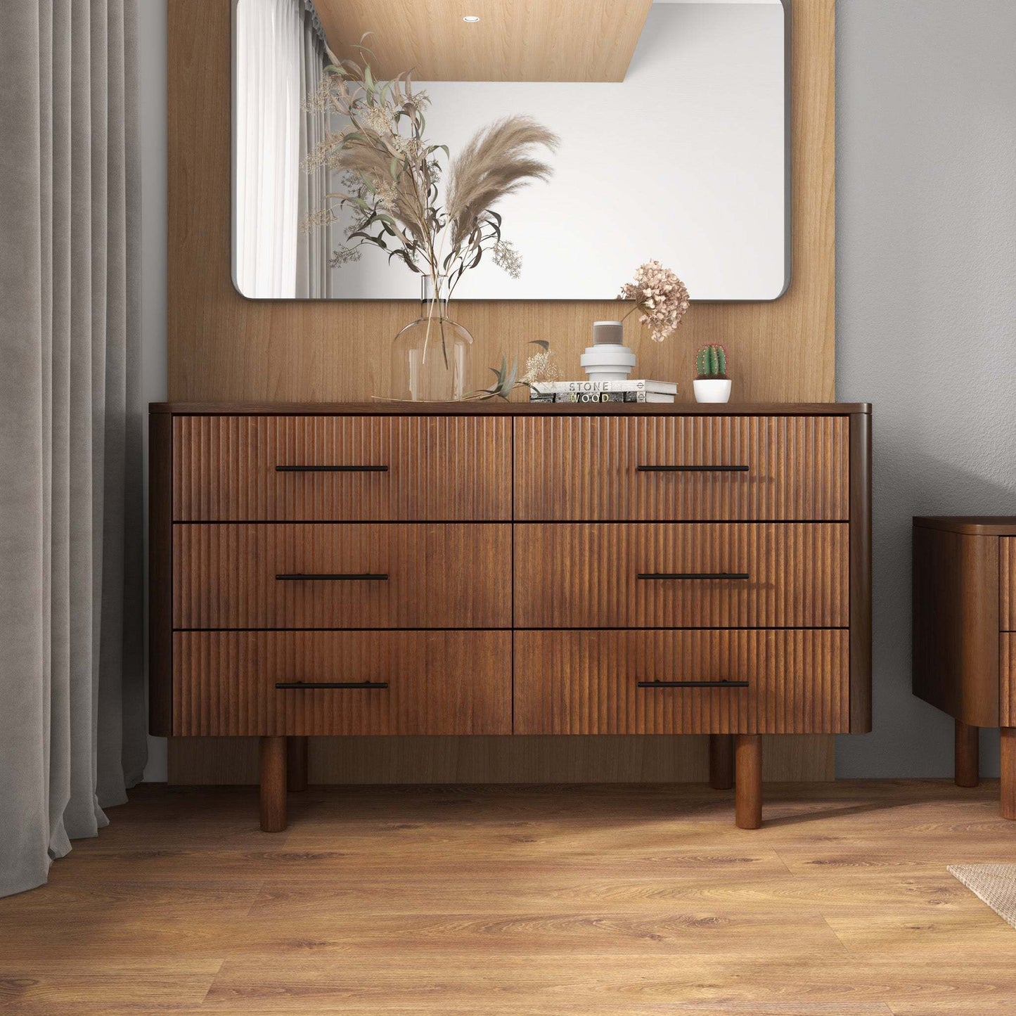 Modern wood dresser with six drawers in a stylish bedroom, decorative vases and books on top