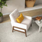 Modern beige armchair with yellow cushion in stylish living room, FredCo International furniture
