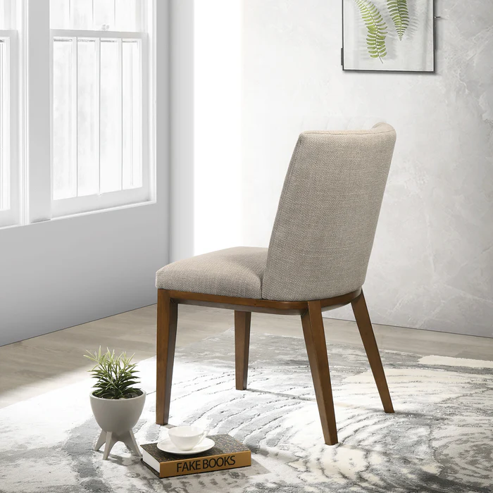 Modern upholstered dining chair with wooden legs in a bright room, FredCo International furniture