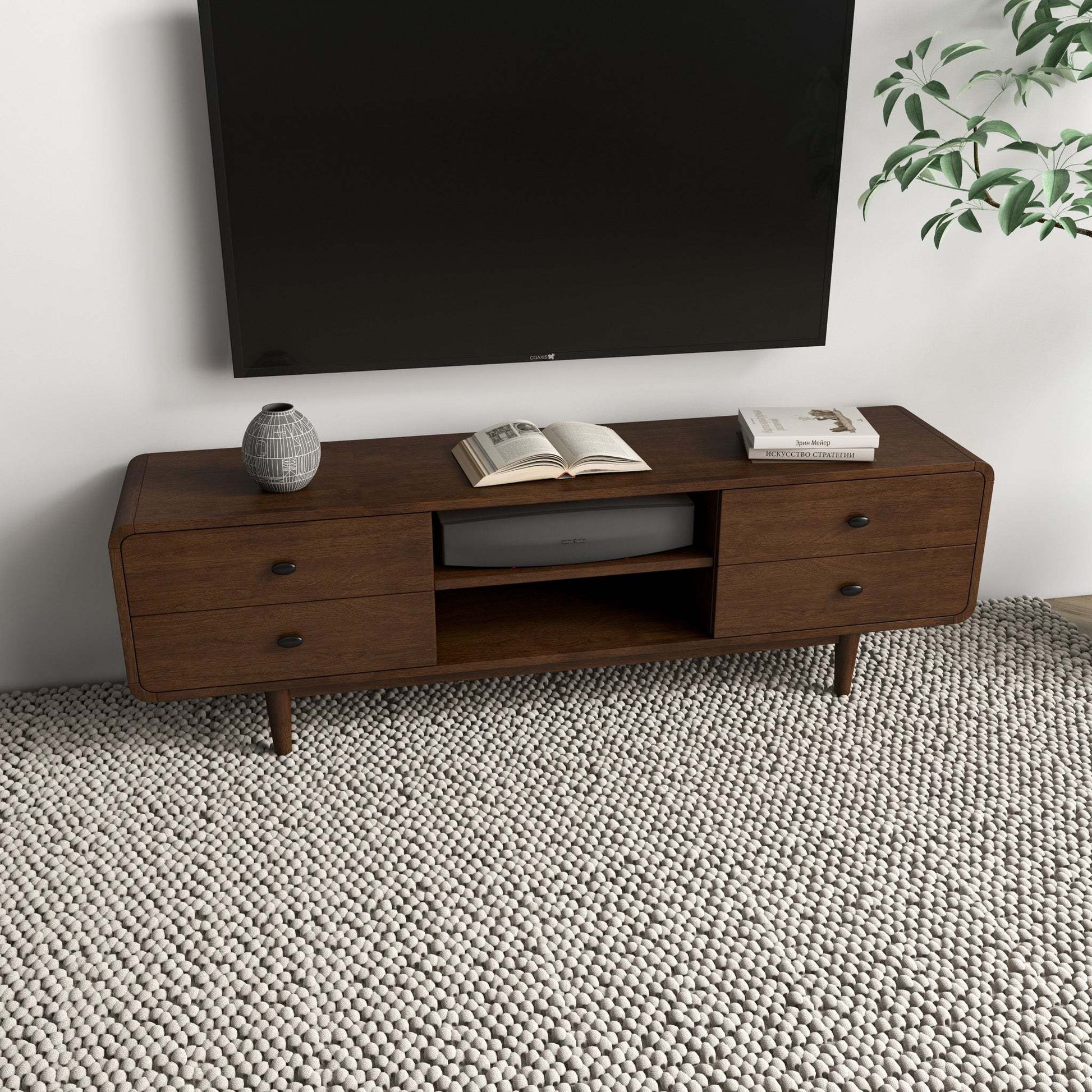 Mid-century modern wood TV stand with drawers, decor vase, and books in living room