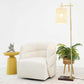 Modern living room with a white plush armchair, yellow side table, floor lamp, and potted plant