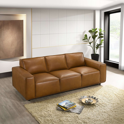 Modern brown leather sofa in a stylish living room with large window, rug, and indoor plant