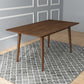Mid-century modern wood dining table on patterned rug in stylish room, FredCo International furniture