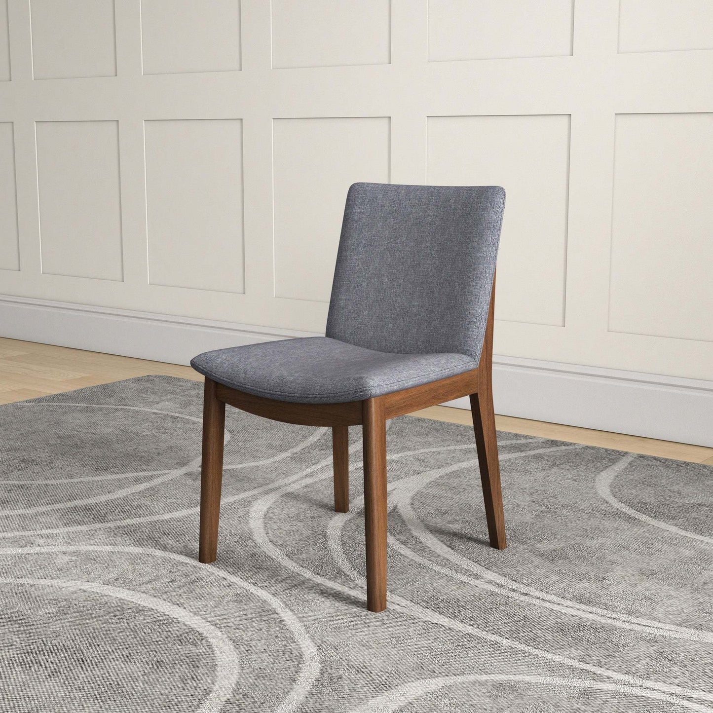 Modern gray upholstered dining chair with wooden legs on a patterned rug in a home setting