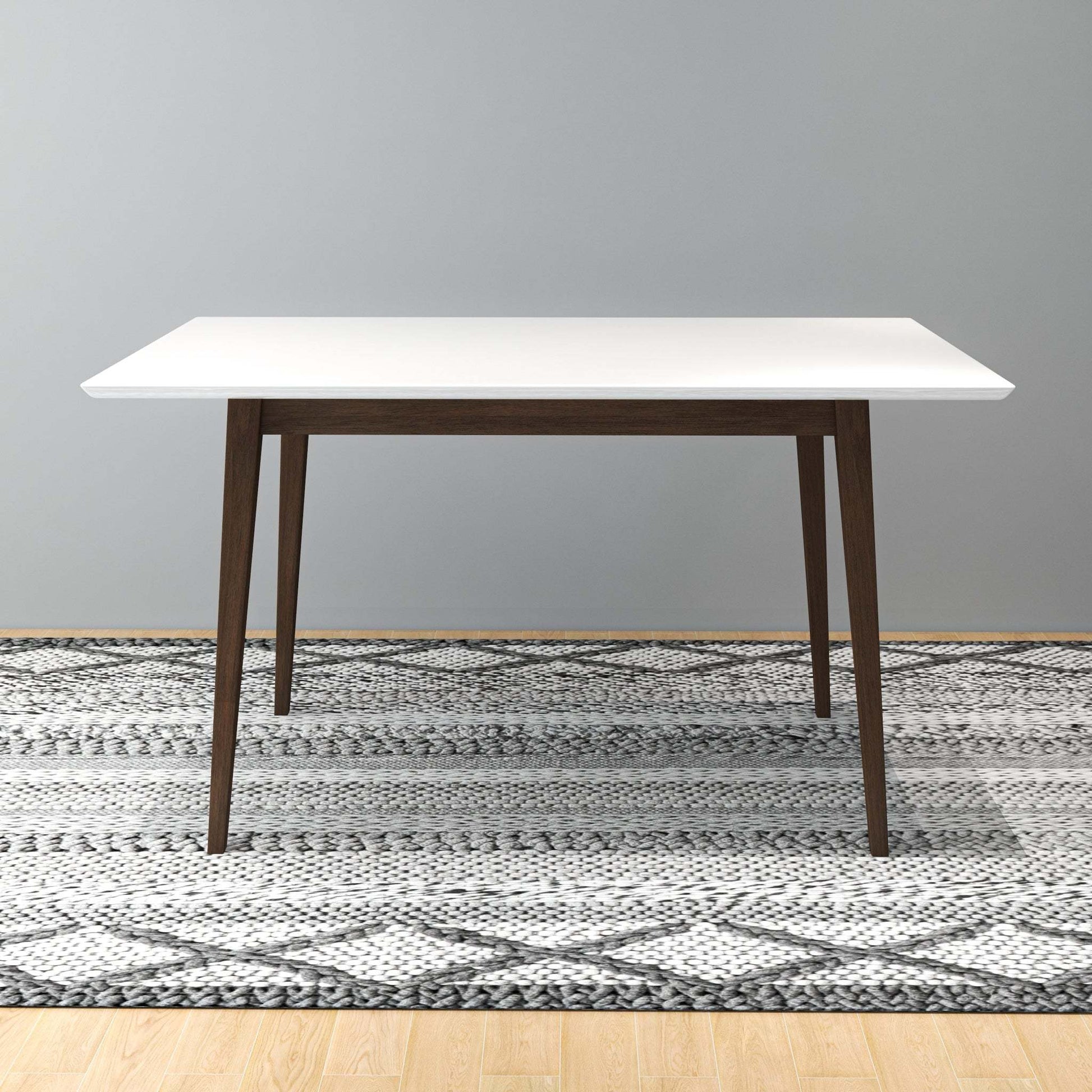 Modern dining table with white top and wooden legs on patterned rug, FredCo International furniture