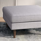 Modern gray upholstered ottoman with wooden legs on patterned rug, FredCo International furniture