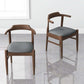 Modern wooden dining chairs with gray cushions on a glossy floor, FredCo International furniture