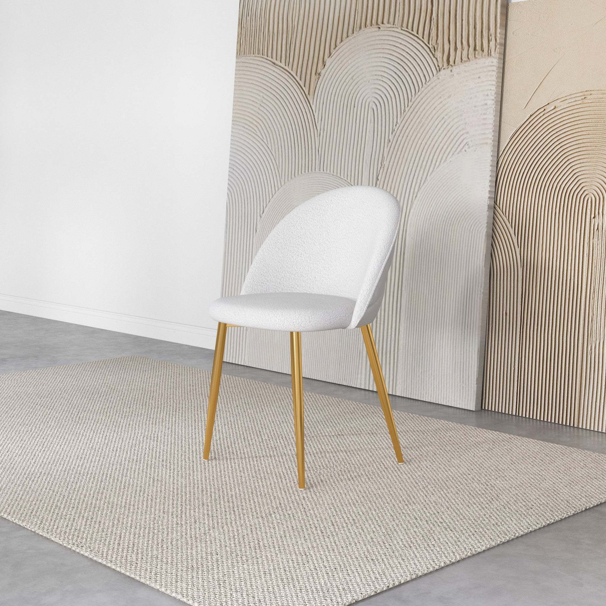 Modern white accent chair with gold legs on beige rug, abstract art background, FredCo International