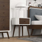 Mid-century modern nightstand with wood drawer and white lamp in stylish bedroom