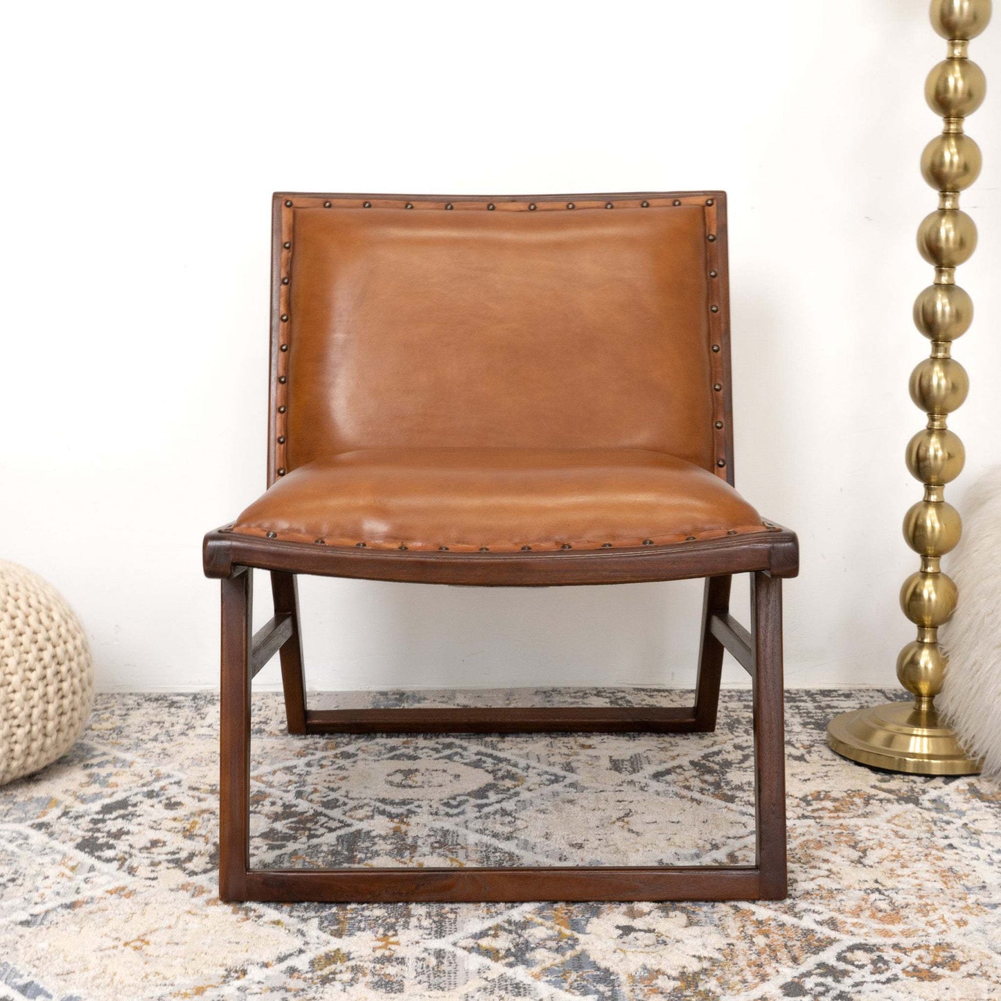 Modern brown leather accent chair with wood frame on patterned rug, FredCo International furniture