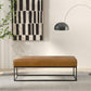 Modern brown leather bench with metal legs in a minimalist living room, FredCo International furniture