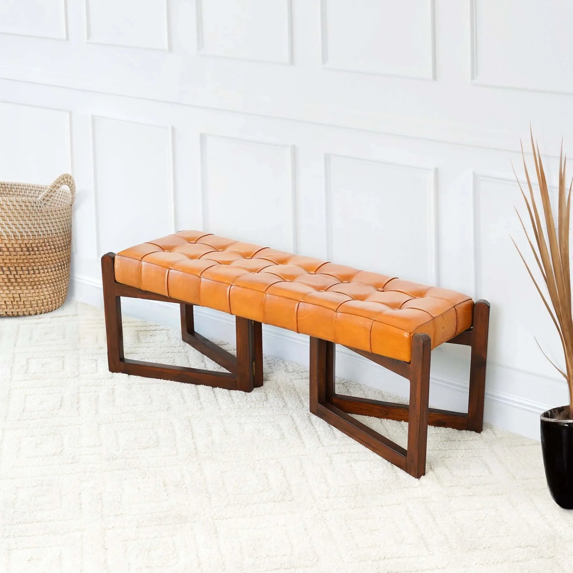 Modern tan leather bench with tufted seat and wooden base in bright living room setting