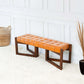 Modern tan leather bench with tufted seat and wooden base in bright living room setting