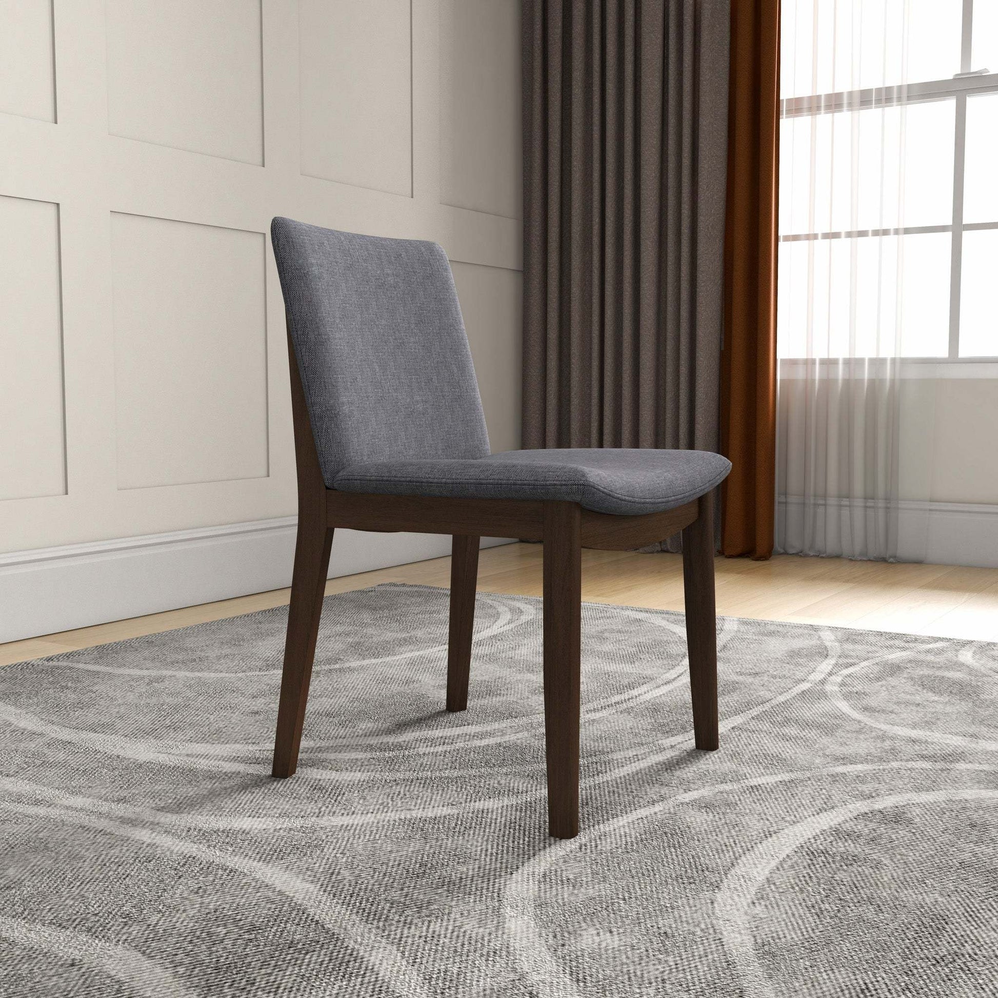 Modern gray upholstered dining chair with dark wood legs on patterned rug in stylish living room