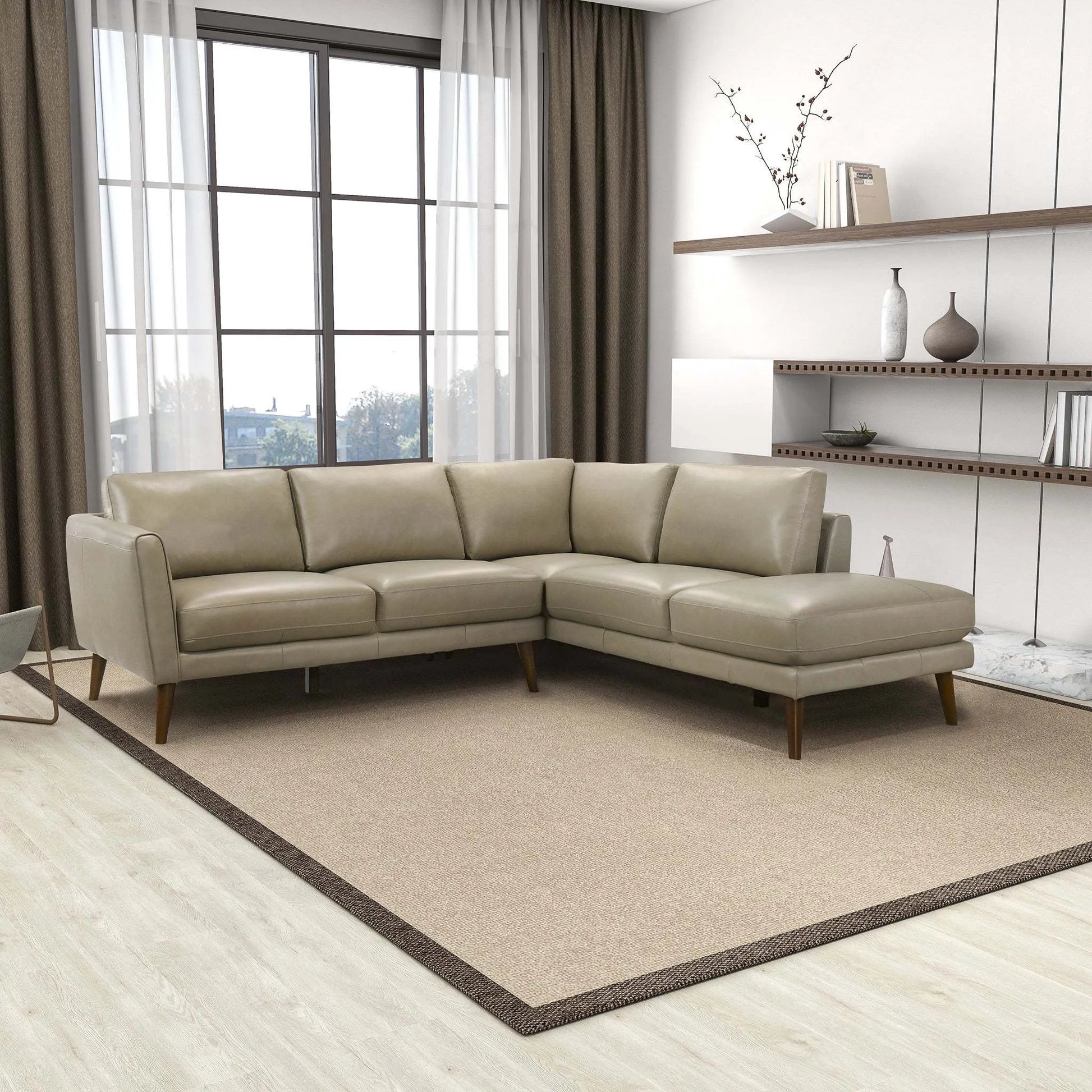Modern beige sectional sofa in stylish living room with large windows and shelves, FredCo International furniture