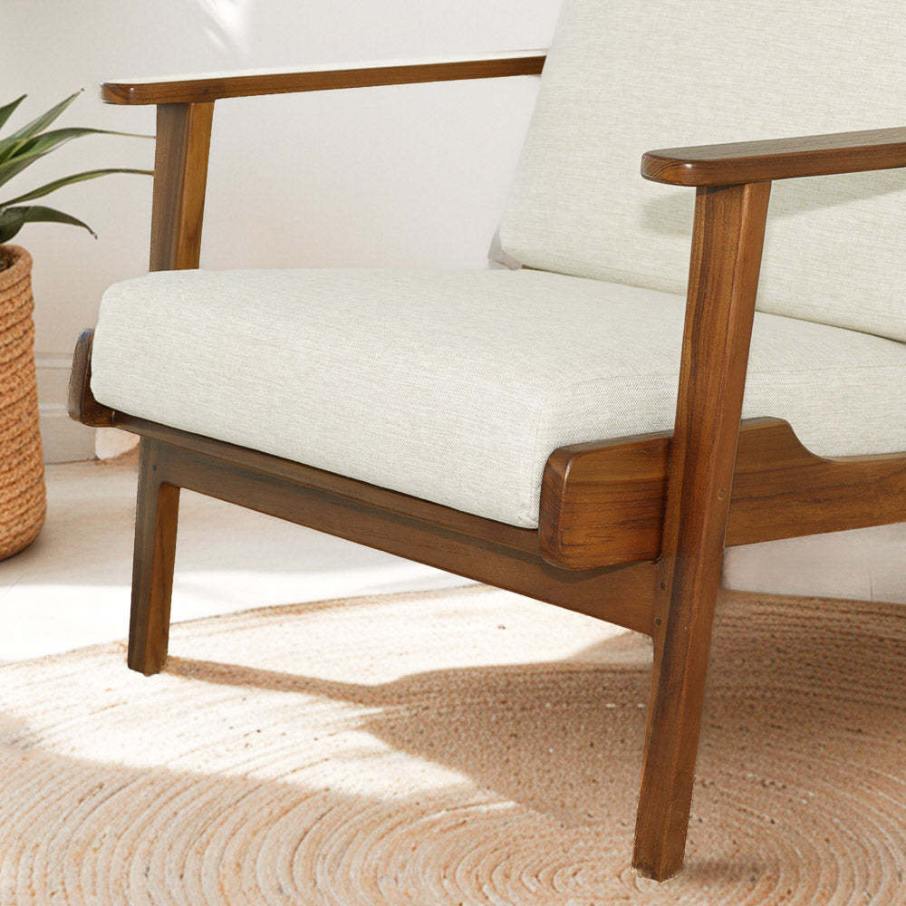 Mid-century modern wooden armchair with beige cushions in a bright living room