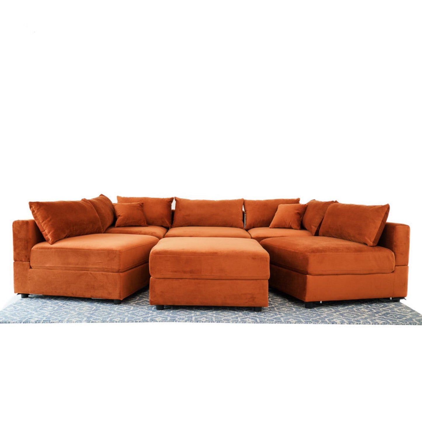 Modern orange sectional sofa with matching ottoman on patterned rug, FredCo International furniture
