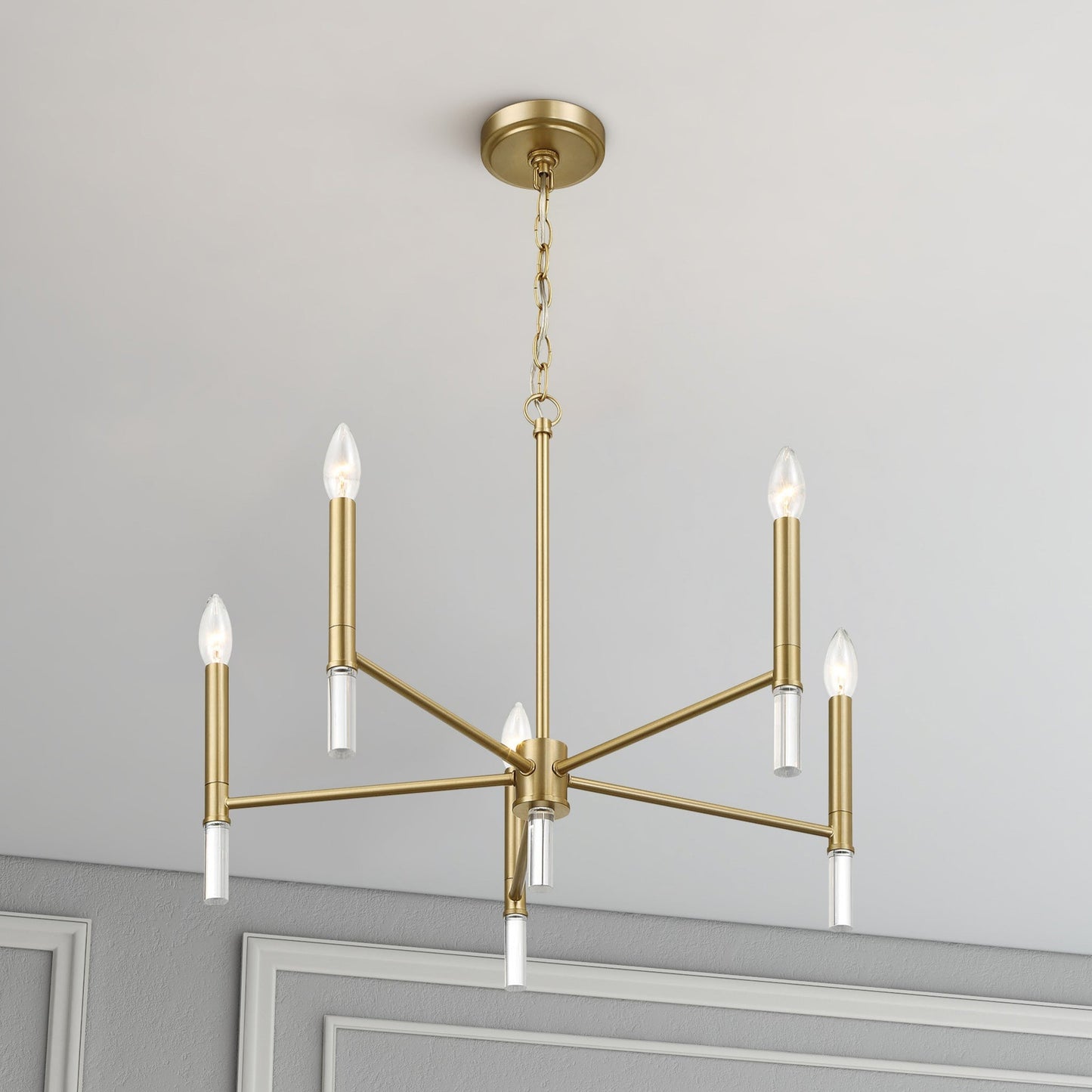 Modern gold chandelier light fixture with six bulbs in a stylish home interior ceiling