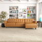Modern tan leather sectional sofa in stylish living room with bookshelves, rug, and decor