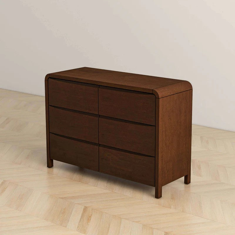 Modern dark wood dresser with six drawers on light wood floor, FredCo International furniture