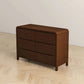 Modern dark wood dresser with six drawers on light wood floor, FredCo International furniture