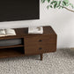 Mid-century modern wooden TV stand with books, under wall-mounted TV on textured rug