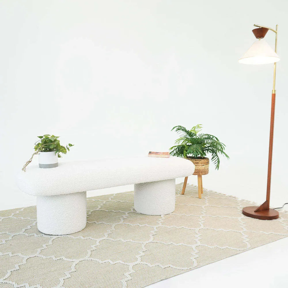 Modern white bench on patterned rug with potted plants and floor lamp, FredCo International furniture
