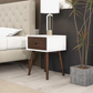Modern nightstand with white frame, dark wood drawer, lamp, and plant in bedroom