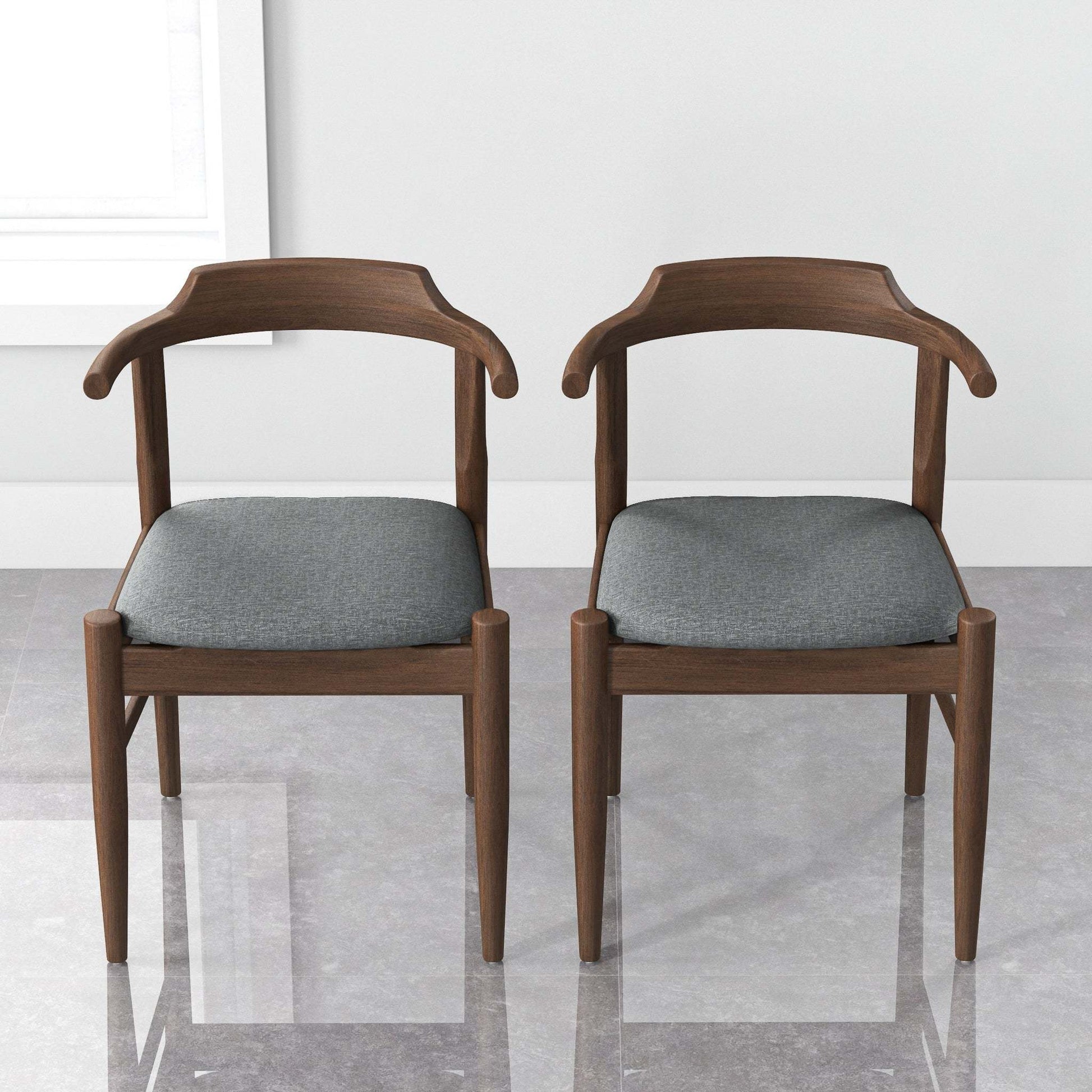 Pair of modern wooden dining chairs with gray cushions in a minimalist room