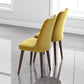 Pair of modern yellow dining chairs with wooden legs on polished floor in bright room