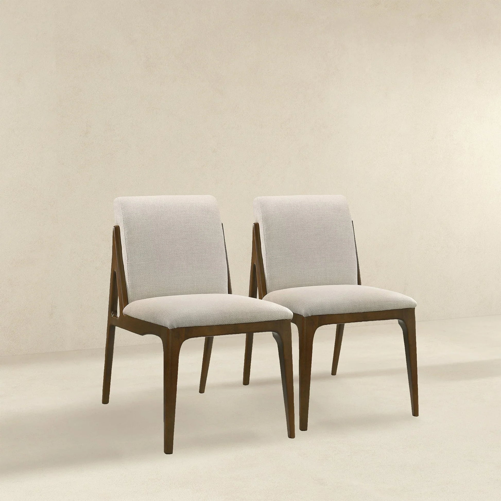 Pair of modern dining chairs with light upholstery and wooden frames, FredCo International