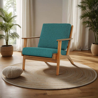 Mid-century modern wooden armchair with teal cushions on a round rug in a bright living room