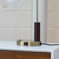 Modern table lamp with USB port on brass base, placed on white wood nightstand