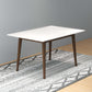 Modern white rectangular dining table with wooden legs on patterned rug, FredCo International furniture
