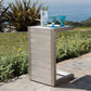 Modern outdoor side table with metal finish, blue glasses and water bottle, garden patio view