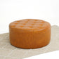 Round tufted leather ottoman on a beige patterned rug, modern furniture from FredCo International