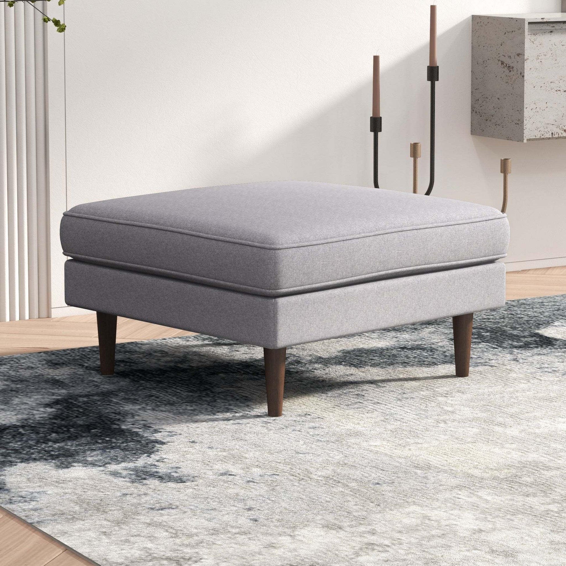 Modern gray ottoman with wooden legs on patterned rug in contemporary living room