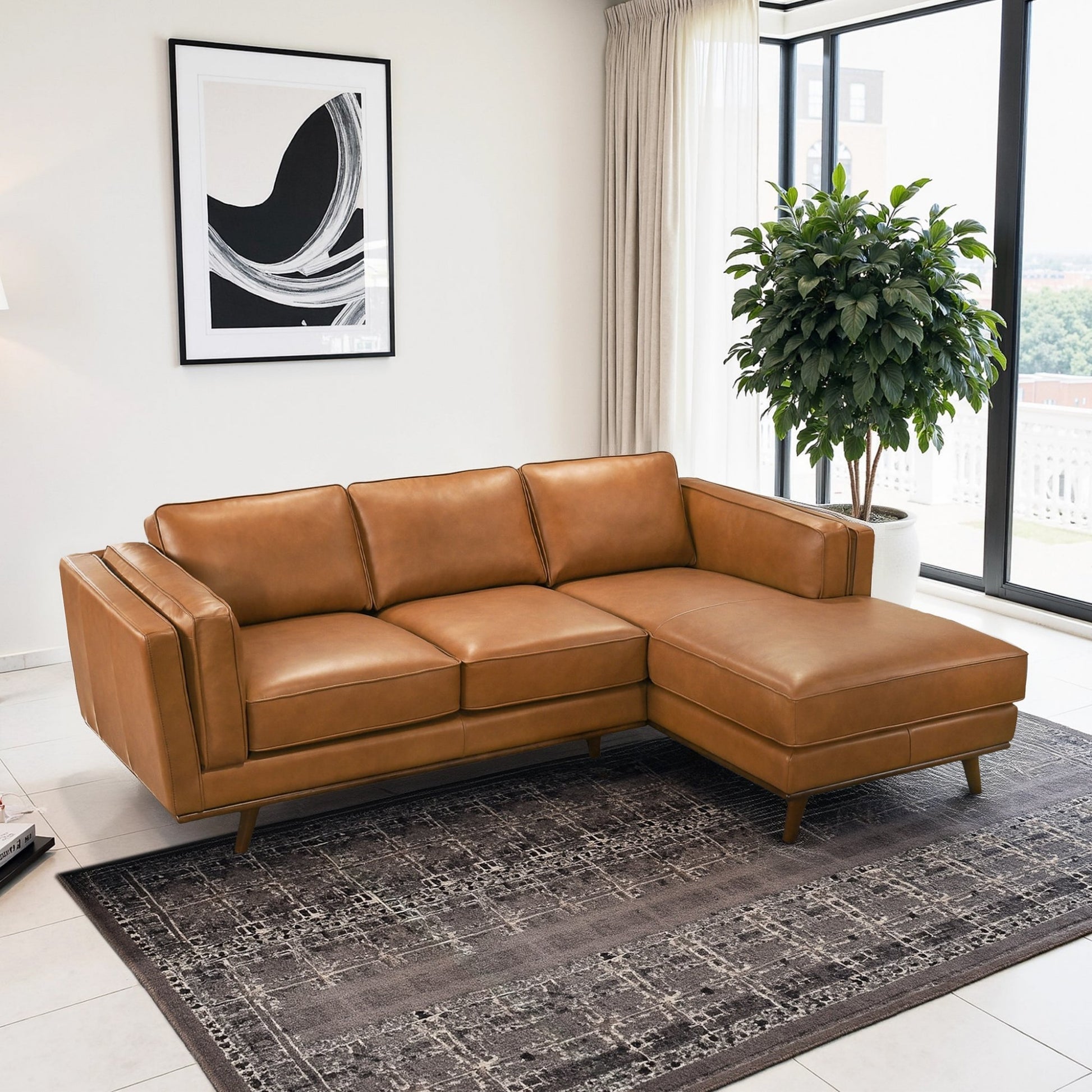 Modern tan leather sectional sofa in bright living room with large windows and indoor plant