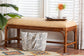 Rattan bench with woven seat in a bright living room, decorative pillow below, tray and vase on top.