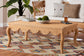 Wicker coffee table with scalloped edges in a cozy living room, on a colorful patterned rug, FredCo International furniture
