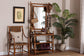 Entryway with bamboo hall tree, woven chair, potted plant, and framed botanical art