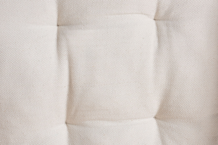Close-up of tufted cream fabric upholstery, furniture detail from FredCo International
