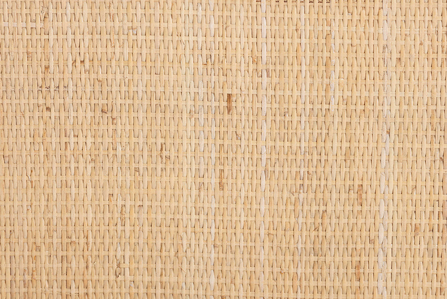 Close-up of natural rattan cane webbing, woven texture for home furniture decor.