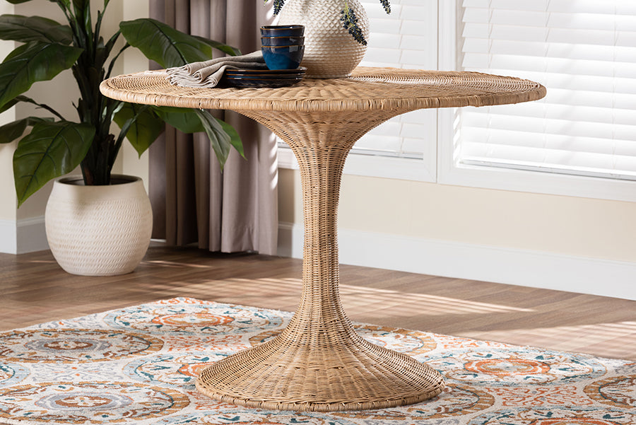 Round wicker dining table with flared base on patterned rug in bright living room
