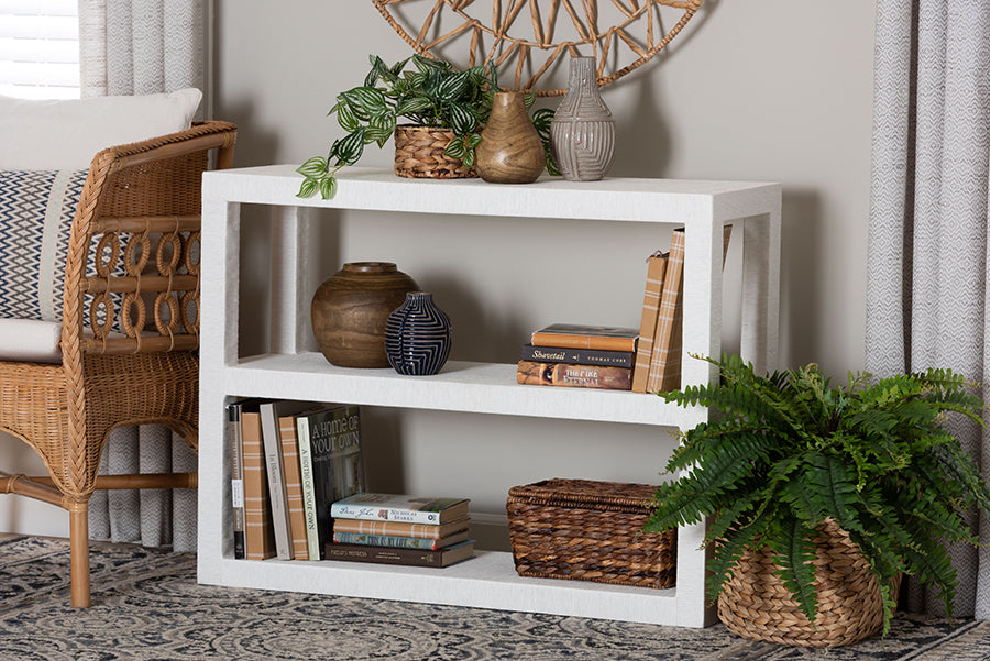 Modern white console table with vases, books, woven baskets, and plants in a cozy living room