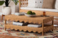 Wicker coffee table with scalloped edges in a cozy living room, styled with books and decor