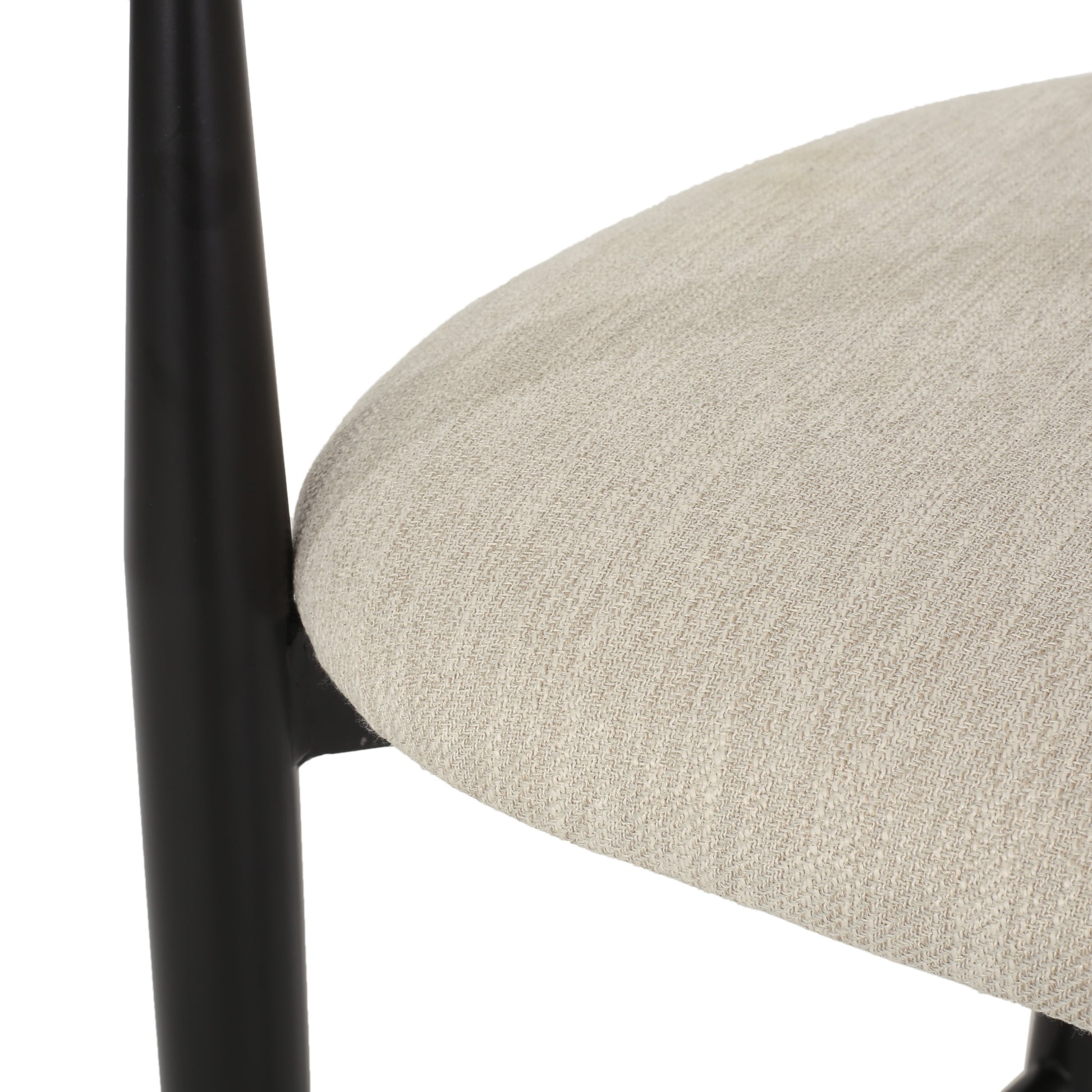 Close-up of beige upholstered dining chair seat with black wood frame