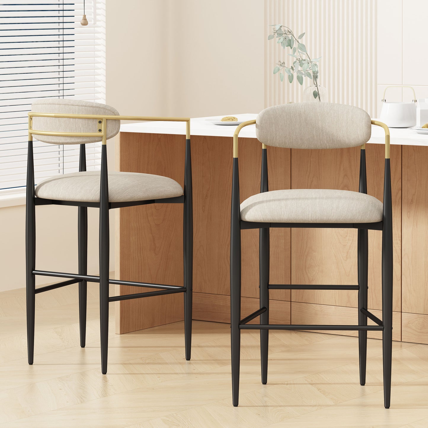 Modern beige and black bar stools with gold accents in a bright kitchen setting, FredCo International furniture.