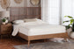 Modern wooden bed frame with white bedding in bright bedroom, FredCo International furniture
